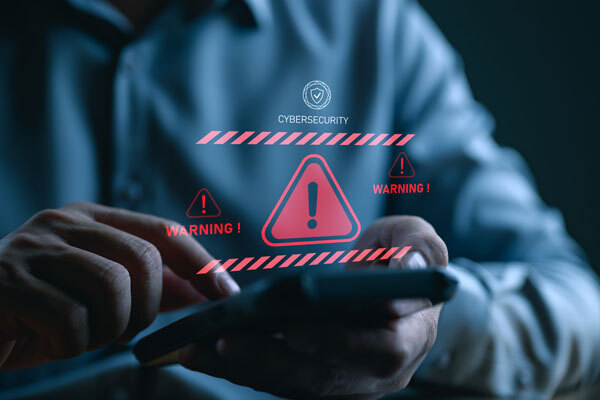 Image of a person using a mobile phone with a danger logo.